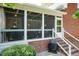 Back of brick home featuring a screened porch with white rails, brick stairs and lush landscaping at 109 Fox Trap Ct, Garner, NC 27529
