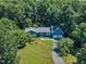 Aerial view of a charming blue home with a two-car garage surrounded by mature trees at 11100 Honeycutt Rd, Raleigh, NC 27614