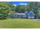 Charming blue home with a two-car garage and mature trees on a well-manicured lawn at 11100 Honeycutt Rd, Raleigh, NC 27614