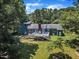 Beautiful blue home with a large deck nestled among mature trees in a lush green yard at 11100 Honeycutt Rd, Raleigh, NC 27614