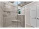 Walk-in shower featuring river rock base, tile surround, glass enclosure, and a skylight at 11100 Honeycutt Rd, Raleigh, NC 27614