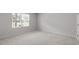 A bright bedroom with a neutral carpet and a large window allowing plenty of natural light at 1114 Crossvine Trl, Durham, NC 27703