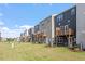 View of back of townhomes with small wooden decks and well-maintained lawn at 1114 Crossvine Trl, Durham, NC 27703