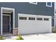 A close up of the front door and garage entrance of a townhome with stone accents at 1114 Crossvine Trl, Durham, NC 27703
