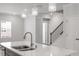 Close up of the quartz counter topped kitchen island with stainless steel sink and pendant lighting at 1114 Crossvine Trl, Durham, NC 27703