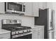 Detailed shot of modern stainless-steel appliances and stylish grey cabinets in a bright kitchen at 1114 Crossvine Trl, Durham, NC 27703