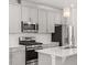 Close up of gourmet kitchen with stainless steel appliances and a quartz countertop island at 1114 Crossvine Trl, Durham, NC 27703