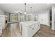 Bright open kitchen and living room area featuring an island and fireplace at 112 Lager Ln, Garner, NC 27529