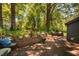 Back yard patio and wall with seating, potted plants, and mature trees at 1120 E Oak Dr, Durham, NC 27712
