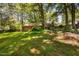 Relaxing backyard featuring a patio set, lush lawn, mature trees, and privacy at 1120 E Oak Dr, Durham, NC 27712