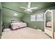 Bedroom with green walls, skylight, ceiling fan, carpeted floor, and vanity with large mirror at 1120 E Oak Dr, Durham, NC 27712