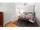 Bright bedroom with wood floors, ceiling fan, and a colorful comforter and pillows at 1120 E Oak Dr, Durham, NC 27712