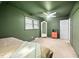 Bedroom with green walls, ceiling fan, carpeted floor, and lots of light from the window at 1120 E Oak Dr, Durham, NC 27712