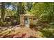 Charming outbuilding with blue door, grill, and fenced yard, perfect for recreation or storage at 1120 E Oak Dr, Durham, NC 27712