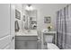 Well-lit bathroom featuring a gray vanity, framed mirrors, and a shower-tub combination with a curtain at 1125 Surveyor Dr, Durham, NC 27703