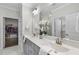 Bathroom with double sink vanity, decorative mirror, and access to a walk-in closet and walk in shower at 1125 Surveyor Dr, Durham, NC 27703