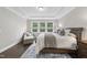 Bedroom featuring large windows, a tray ceiling, and a neutral color palette throughout the room at 1125 Surveyor Dr, Durham, NC 27703