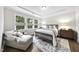 Bright bedroom featuring large windows, a tray ceiling, and a sitting area with a comfortable chaise lounge at 1125 Surveyor Dr, Durham, NC 27703