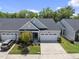 Charming single-Gathering home with a gray exterior, manicured lawn, and a two-car garage at 1125 Surveyor Dr, Durham, NC 27703