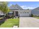 Inviting home exterior featuring a well-kept lawn, stone accents, and an attached two-car garage at 1125 Surveyor Dr, Durham, NC 27703