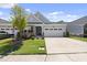 Charming townhome exterior with a driveway, garage, and well-maintained lawn at 1125 Surveyor Dr, Durham, NC 27703