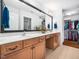 Well-lit bathroom with double sinks, wood cabinetry, and a walk-in closet for ample storage at 1167 Blue Bird Ln, Wake Forest, NC 27587