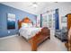 Bedroom with blue accent wall, plush carpet, and natural light from shuttered windows at 1167 Blue Bird Ln, Wake Forest, NC 27587