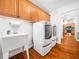 Bright laundry room with modern washer and dryer, utility sink, and built in cabinet storage at 1167 Blue Bird Ln, Wake Forest, NC 27587