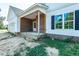 Close up of charming covered front porch with brick pillars and freshly installed black window shutters at 1229 Lawndale Dr, Graham, NC 27253