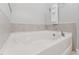 White bath tub with chrome faucet, white towel and grey tile trim at 125 Alumroot Rd, Holly Springs, NC 27540