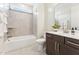 Modern bathroom featuring a combined shower and bath, tile accents and dark wood vanity at 125 Alumroot Rd, Holly Springs, NC 27540