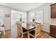 Dining room filled with natural light has a wood table, seating for six, and hardwood floors at 125 Alumroot Rd, Holly Springs, NC 27540