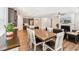 Open dining room featuring hardwood floors, a stylish table, and a view of the living area at 125 Alumroot Rd, Holly Springs, NC 27540