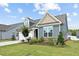 Beautifully landscaped home featuring stone accents, blue siding, and a well-manicured lawn at 125 Alumroot Rd, Holly Springs, NC 27540