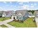 Inviting home boasts pristine lawn, attached garage, and lovely architectural details at 125 Alumroot Rd, Holly Springs, NC 27540