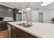 Bright kitchen island with a stainless steel sink, pendant lights, and shaker cabinets at 125 Alumroot Rd, Holly Springs, NC 27540