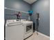 Practical laundry room with modern washer and dryer, storage rack and a fire extinguisher at 125 Alumroot Rd, Holly Springs, NC 27540