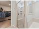 Bright bathroom featuring walk-in shower with seat, and acces to the walk-in closet at 125 Alumroot Rd, Holly Springs, NC 27540