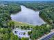 Aerial image features a scenic lake surrounded by trees, complemented by nearby parking and road access at 1276 Dalgarven Dr, Apex, NC 27502