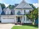 Charming two-story home with a manicured lawn, attached garage, and inviting front porch at 1276 Dalgarven Dr, Apex, NC 27502