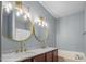 This bathroom features double sinks, marble countertops, and modern gold fixtures at 145 Mariah Towns Way, Garner, NC 27529