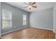 This empty bedroom has laminate wood floors, 2 windows for natural light, a ceiling fan at 145 Mariah Towns Way, Garner, NC 27529