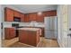Open kitchen with stainless steel appliances, hardwood floors, a center island, and dark wood cabinets at 145 Mariah Towns Way, Garner, NC 27529