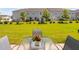 Manicured backyard featuring well maintained lawn, patio set, and new townhome construction at 150 Gosford Ln, Garner, NC 27529