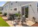 Cozy backyard patio with a glass table, four chairs, grill, privacy fence, and small garden at 150 Gosford Ln, Garner, NC 27529