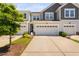 View of the townhome with a two-car garage and a well-maintained lawn at 150 Gosford Ln, Garner, NC 27529