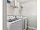 Well-equipped laundry room with modern washer and dryer units and shelving for storage at 150 Gosford Ln, Garner, NC 27529