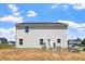 View of the home's rear exterior with small patio and chairs at 16 Powder Ct, Angier, NC 27501