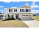 Charming two-story home features beige siding, a two-car garage, and a well-maintained front yard at 16 Powder Ct, Angier, NC 27501
