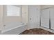 Bright bathroom featuring a soaking tub, shower with glass doors, and neutral decor at 16 Woodglen Dr, Clayton, NC 27527